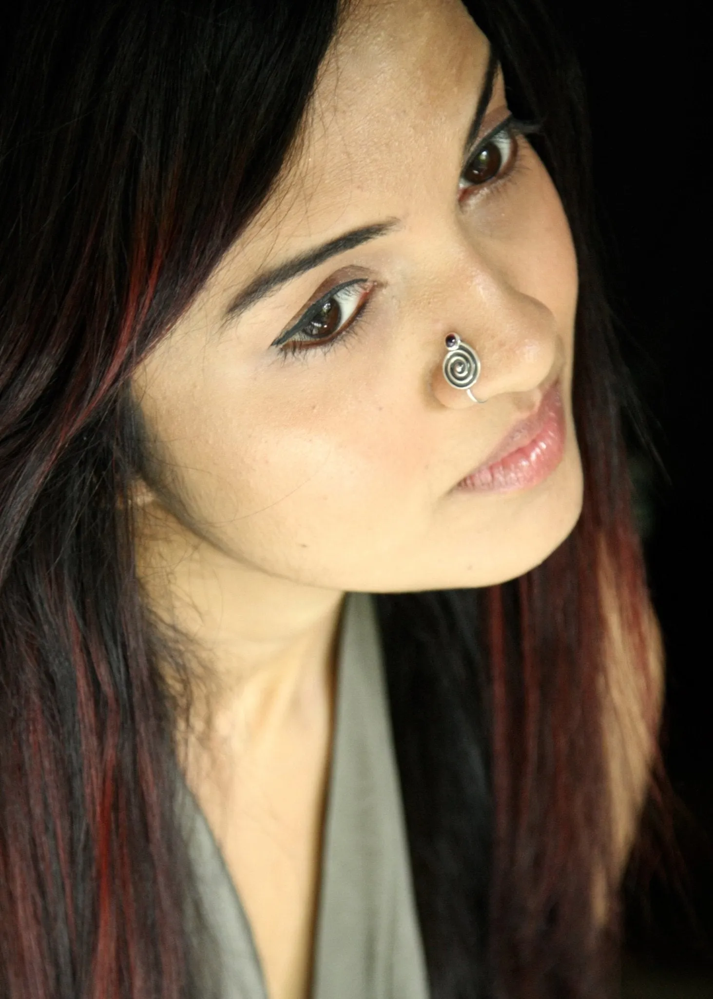 Arresting, spiral nose pin set with a garnet